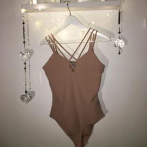  - Fin beige body från Charlotte russe med band över brösten. Aldrig använd, bara testad i butik. ♡ Kan mötas upp i Växjö, annars står köparen för frakt. Betalning sker helst via swish men funkar inte det så går det att lösa! Bara kontakta mig om du har frågor eller vill se mer! ♡ 