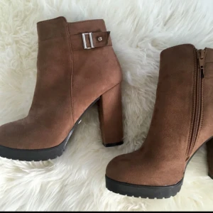  - Snygga ankelboots med klack från Tiamo. Inköpt på Scorett för 700 kr. Använt endast en kväll så de är som nya. Material: Mocka. Färg: Brun. 