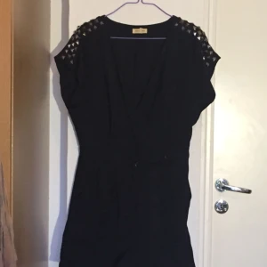  - Black onepiece with shorts, embroidery on the upper part of sleeves.