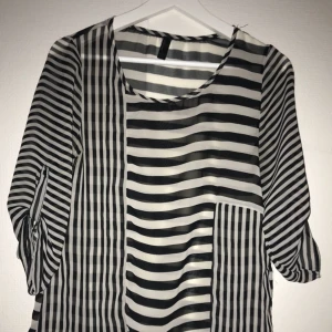  - Fin randig blus i transparent (genomskinligt) material. Uppvikbara ärmar med knapp. Oanvänd😊