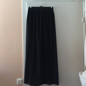  - Lång kjol har en kortare underkjol och är öppen båda sidorna i benen. ALDRIG använd 