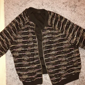  - Kofta i bombermodell med färgglada och glittriga broderier i tyget, guldiga detaljer. Sparsamt använd. Köparen står för frakten som kostar 58, betalning sker via swish eller kontoöverföring! 