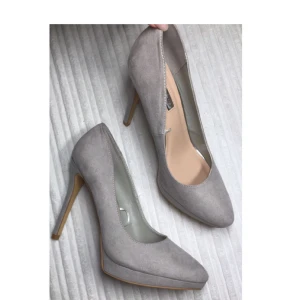  - Mocka pumps från Primark strl 38. Aldrig använda. Färgen är beige/grå (svårt att få med på bild) köparen står för ev frakt   Klackhöjd: 11,5 cm Platå: ca 1,5-2cm   