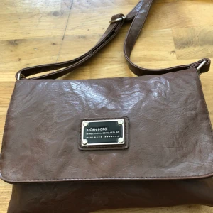  - Fin axelremsväska från Björn Borg i brunt läder.