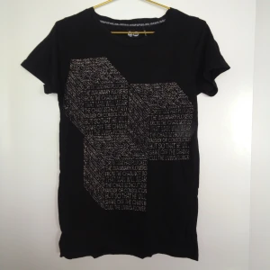  - Svart T-shirt med tryck från Cheap Monday. Skick: Som ny. Gratis frakt!