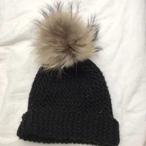  - Mössa med pälsboll. Aldrig använd.