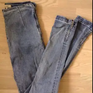 Högmidjade ljusblå jeans i tight stretchig modell från Whyred. Dragkedja vid byxslut samt på sidan istället för gylf och knapp.