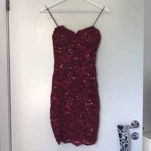  - Glittrig vinröd tight klänning från Nelly. Aldrig använd.