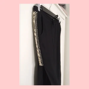  - Svarta, vida byxor med slits på sidan av vardera ben och handsydda stenar. Från italienska märket MET, nypris 1200kr. Aldrig använda pga fel storlek. 