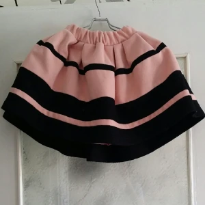  - Rosa filtkjol. Står ut som en blåklocka när man har på sig den, har fickor på sidorna. Aldrig använd. 