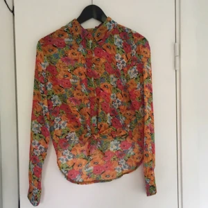 - Blommig halvtransparent-skjorta från Boohoo! Oanvänd! Bra skick! Crop-top liknande där fram! Köparen står för frakten! Betalningen sker via swish! 