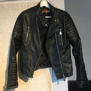 Voyelles skinnjacka  - Klassiska voyelles jackan. Köpt på Plick men kom aldrig till användning. Trasig söm på insidan av ryggen och lappen är lös men inget som syns + plus kan lagas. Köpare står för frakt 🥰 Möts ej upp! 