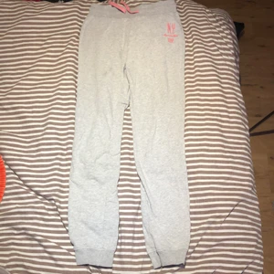 Mjukisbyxor i storlek 158/164 - Gråa Mjukisbyxor med rosa text i storlek 158/164, bra skick, säljer för denne för kort på längden