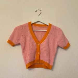 Färgglad stickad kofta/ topp  - Rosa stickad topp med detaljer i orange. One size men passar Xs-M beroende på hur man vill att den ska sitta. Nyskick, köpare står för frakt 