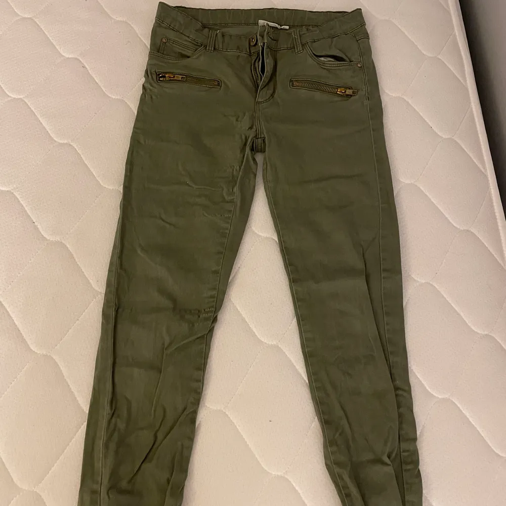Militärgröna jeans med guldiga detaljer. köpare står för frakt, kontakta för fler bilder eller frågor. Jeans & Byxor.