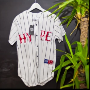  - Oanvänd HYPE. tröja med taggar kvar. 
Cool tröja med knapp-knäppning på framsidan, i baseball-stil. Tryck på fram- och baksida, broderad text på framsidan.
Säljes då den inte passar min stil.