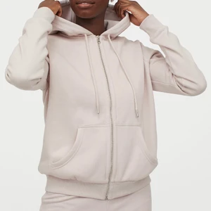 Huvtröja Aprikos/rosa/beige  - Storlek M Använd 2 gånger, men den är precis som ny Sitter som en normal hoodie med luva Den är snygg om du är i storlek S/XS men vill ha lite oversized Mysigt material på insidan//En munkjacka i sweatshirtkvalitet. Jackan har fodrad huva med dragsko, dragkedja fram samt sidfickor. Mudd nedtill och vid ärmslut.