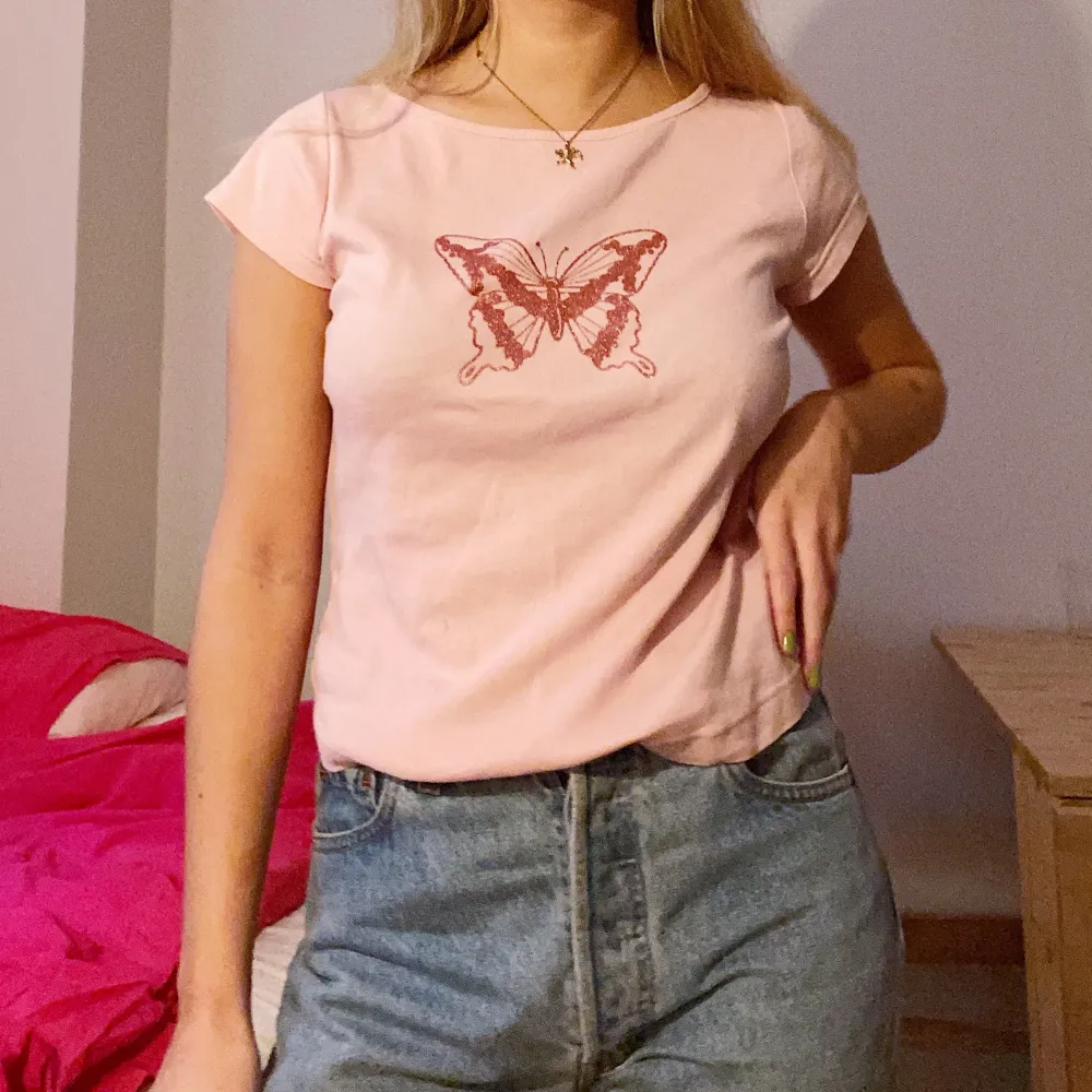 En liten rosa t-shirt med fjärilstryck som jag hittat second hand, 90/y2k-vibe! Frakt tillkommer eller så kan jag mötas upp i sthlm :). T-shirts.