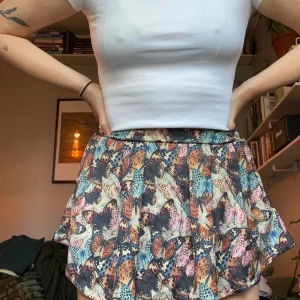 Jättefin kjol med fjärilsmönster - Så härlig kjol i kortare modell! Den har shorts insydda under vilket är bra ifall den blåser upp lite :) Strl L men ganska små för att vara large. Bra skick! Frakt tillkommer