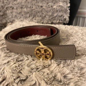 Tory burch bälte aldrig använt - Säljer mitt tory burch bälte jag köpte i vintras för att det aldrig nånsin kommit till användning. Man kan vända ut o in på det så är det mörkrött och annars e de grå/brunt. Såklart äkta, det är den minsta storleken i midjan men har gjort till 3 hål med hålslagare.  Nypris e runt 1500