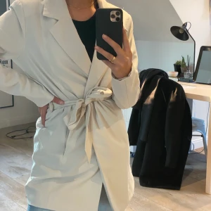 Only - En beige/vit kappa för vår samt tidig höst från Only, med knytning i midjan. Bara använd 2 gånger, därför väldigt bra skick. Köpte den förra året så tror ej den går att få tag i. Vill du veta mer eller få fler bilder skriv! 