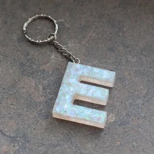 Nyckelring vit  - Betalning sker innan jag gör nyckelringen. Detta pga tidigare oseriösa köpare. ⚠️ Beställ din egna unika nyckelring med valfri bokstav (A-Z) enligt bild. Dessa görs för hand och varje nyckelring blir därför unik. Leveranstiden är lite längre (ca 3-5 dagar) då de måste härda ordentligt innan de skickas. Självklart får du en bild på din nyckelring när den är färdig! 😊🌺 Fått så många fina kommentarer om min egna nyckelring. 😍 Frakt tillkommer.