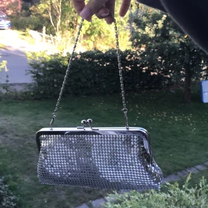 Söt silvrig 90-tals väska! - Passar till alla outfits. Super fin. Axelremsväska, men långt band tillhör :) Buda i kommentarerna, orginalpris 89 kr.