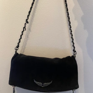 Zadig väska  - Zadig rock suede clutch. Nypris 3200kr, köpt 2018. Väskan är i gott skick däremot finns det slitage på kedjan (se bild 2)
