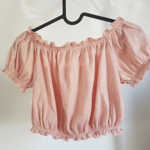 Off shoulder topp - Jättesöt rosa offshoulder crop top från HM. Använd vid ett tillfälle. Säljes då den är för liten. Storlek XS. Frakt ingår.
