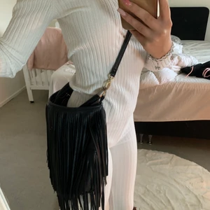 Väska med fransar - Väska från hm med fransar, den stora dragkedjan är trasig men småfacken inuti är felfria. Axelremmen går att ta av och sätta på. Priset är inklusive frakt