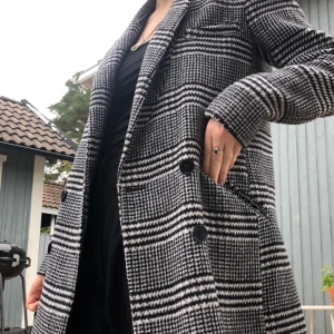 Rutig kappa  - Perfekt höstkappa! Passar till det mesta samtidigt som den sticker ut lite. Buda :) 