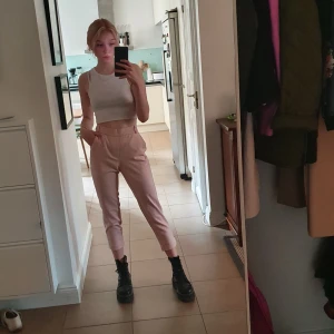 Kostymbyxor  - Rosa kostymbyxor med vita ränder på sidorna. Storlek XS men jag skulle säga att de passar S/M bättre.  (Har justerat byxorna så de ska se ut som de gör när de passar. De är alltså för stora för mig egentligen) Frakt tillkommer, kan även mötas upp i Stockholm.