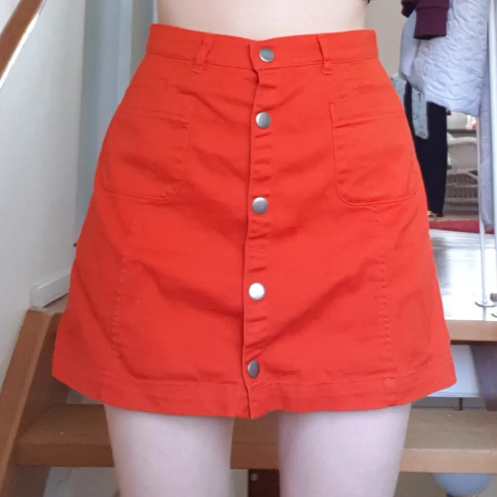 Orange kjol från Monki i strlk 36 med tryckknappar. Använd 1-2 ggr. Kan mötas upp i Sthlm eller frakta. Svarar gärna på frågor om plagget. :). Kjolar.