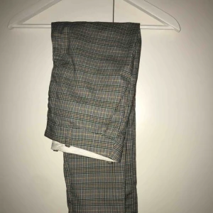  - Rutiga kostymbyxor i brunt, grönt, svart och vitt. Org. från hm. 60kr ink. frakt, kan annars mötas upp i tranåsområdet. Inte stretchiga men sitter fint på. Har fickor. 