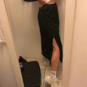  - Svart långkjol med spetsdetaljer längs fållen. Står storlek XL men skulle säga mer L, och den sitter ok på mig med S/M. Vintage, fint skick. Köparen står för frakt 40kr.