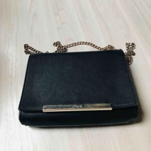  - Axelväska i fejkläder med dragkedja på insidan. 