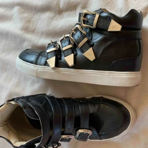  - Svarta sneakers med snygga detaljer från Nelly.  Storlek 36.  Fint använt skick.   Finns en mil från Umeå (kan tas till centrum).  Skickas mot fraktkostnad