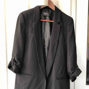  - Svart kavaj med detalj på ärmarna. Storlek M. Använd 1-2 gånger så den är som ny. Kan skickas, köparen står för frakten. Hämtas i Onsala.