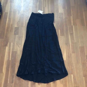  - Oanvänd midikjol i sidenmaterial