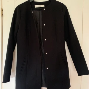 Kappa från Jaqueline de Yong - Svart kappa från Jaqueline de yong, den är lite figursydd. Superfin och stilren. Den är sparsamt använd. Skriv om du vill ha bild hur den ser ut på. Pris kan ev diskuteras. Köparen står för frakt🥰