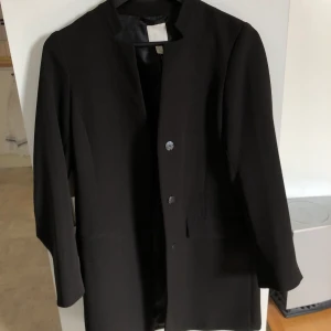 Svart kappa - Svart snygg kappa från H&M🥰Köptes i början av året och är inte använd så många gånger. Storlek 34 men skulle säga att det är mer som en 36/38 då jag utan problem fått plats med en tjock tröja och dunväst under