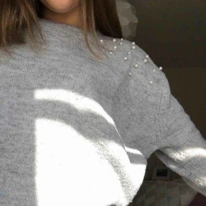  - En grå stickad tröja med pärlor på axen. Den är väldigt stor i storleken. Inte använd så många gånger.  Köpare står för frakt. 