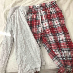  - Oanvänd pyjamas. Rutiga byxor och tillhörande tröja 