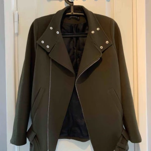  - Militärgrön bikerjacka i tyg. Från Zara. Storlek S, men den är något stor i storleken så den passar även en M. Lite tjockare i tyget så den är perfekt på våren och tidig höst. Fint skick.
