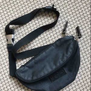  - Svart glittrig magväska från Eastpak! Använd men i mycket bra skick 💌Frakt tillkommer med 36kr💌