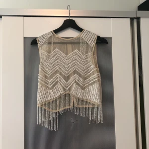  - Ascool partytopp från ASOS. Använd en gång. Broderat beiged meshtyg med vita och silvriga paljetter och pärlor.