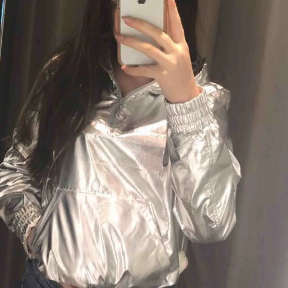 Skit cool silver ”vindjacka” från H&M, deras coachella kollektion. Säljer pågrund av ingen användning längre. Jättebra skick även fast den är använd rätt mycket. Man kan dra åt den och knyta vid midjan/magen.. Jackor.