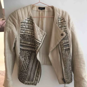  - Beige jacka med metalldetaljer från Lindex. 