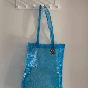 En blå genomskinlig väska som är köpt på humana.                  Storlek: 37 cm hög och 30 cm bred. Säljer för 80kr ink frakt❤️