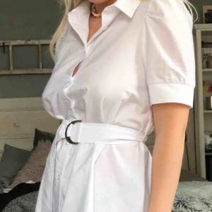  - Vit klänning en skjorta-klänning i strl 36 från nakd den slutar över knäna, aldrig använd! Fraktas eller möts i Örebro 